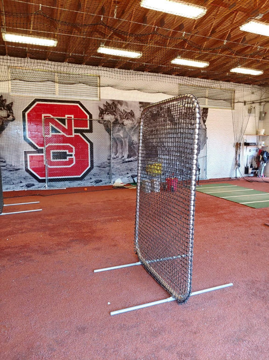 A baseball field with a net and a wall