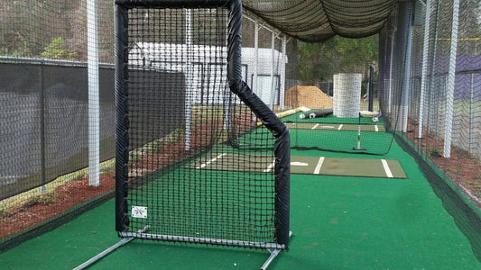 A baseball field with a batting cage and a batting cage.