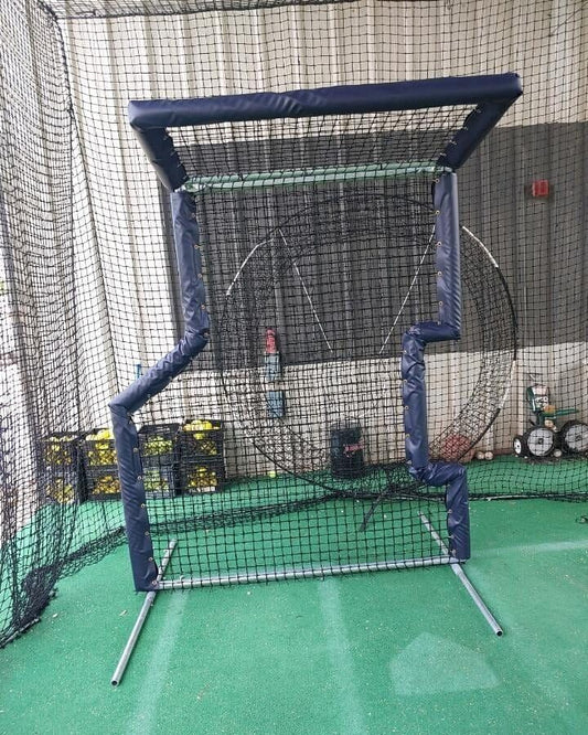 A baseball cage with the net in front of it.