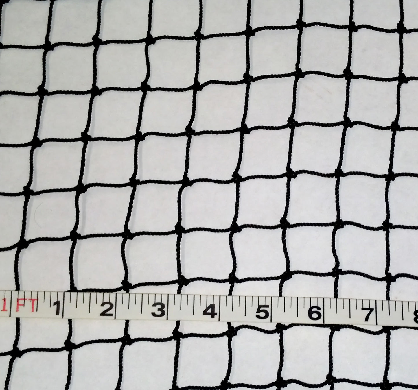 A white cloth with black netting and a ruler