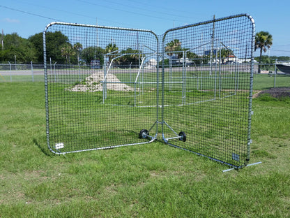 A baseball cage in the middle of a field.