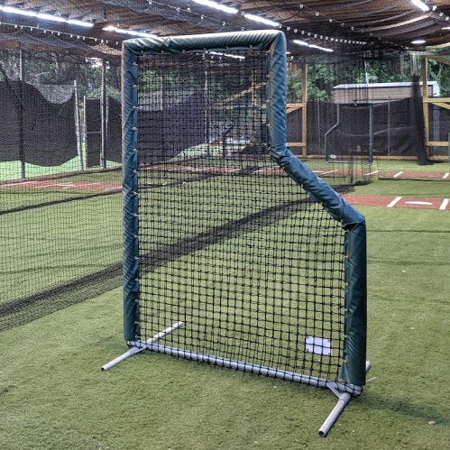A baseball field with a net and batting cage.