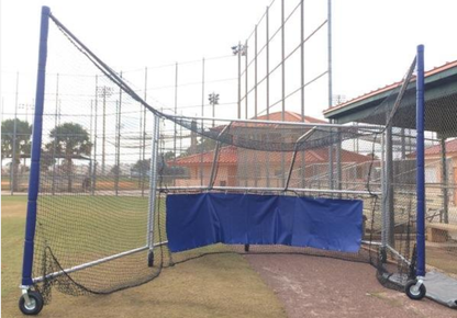 A baseball field with a blue tarp covering the batting cage.