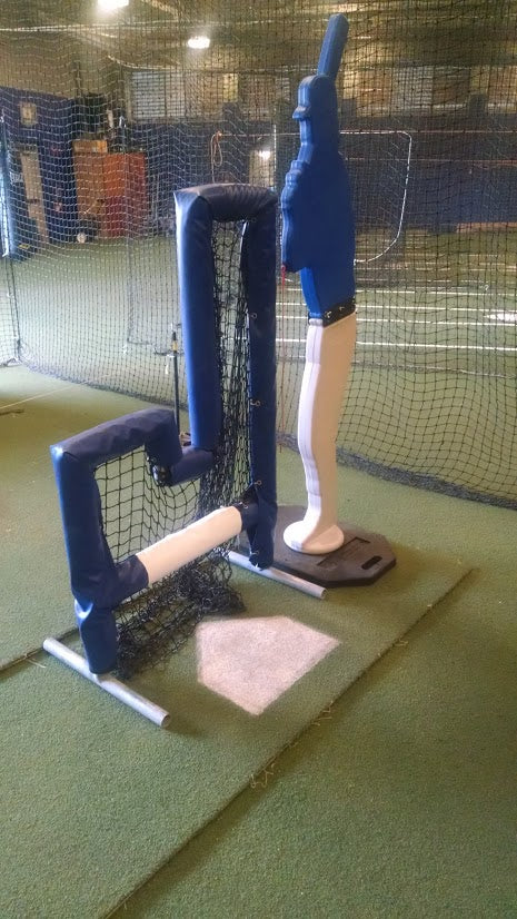 A baseball player is standing in front of the batting cage.
