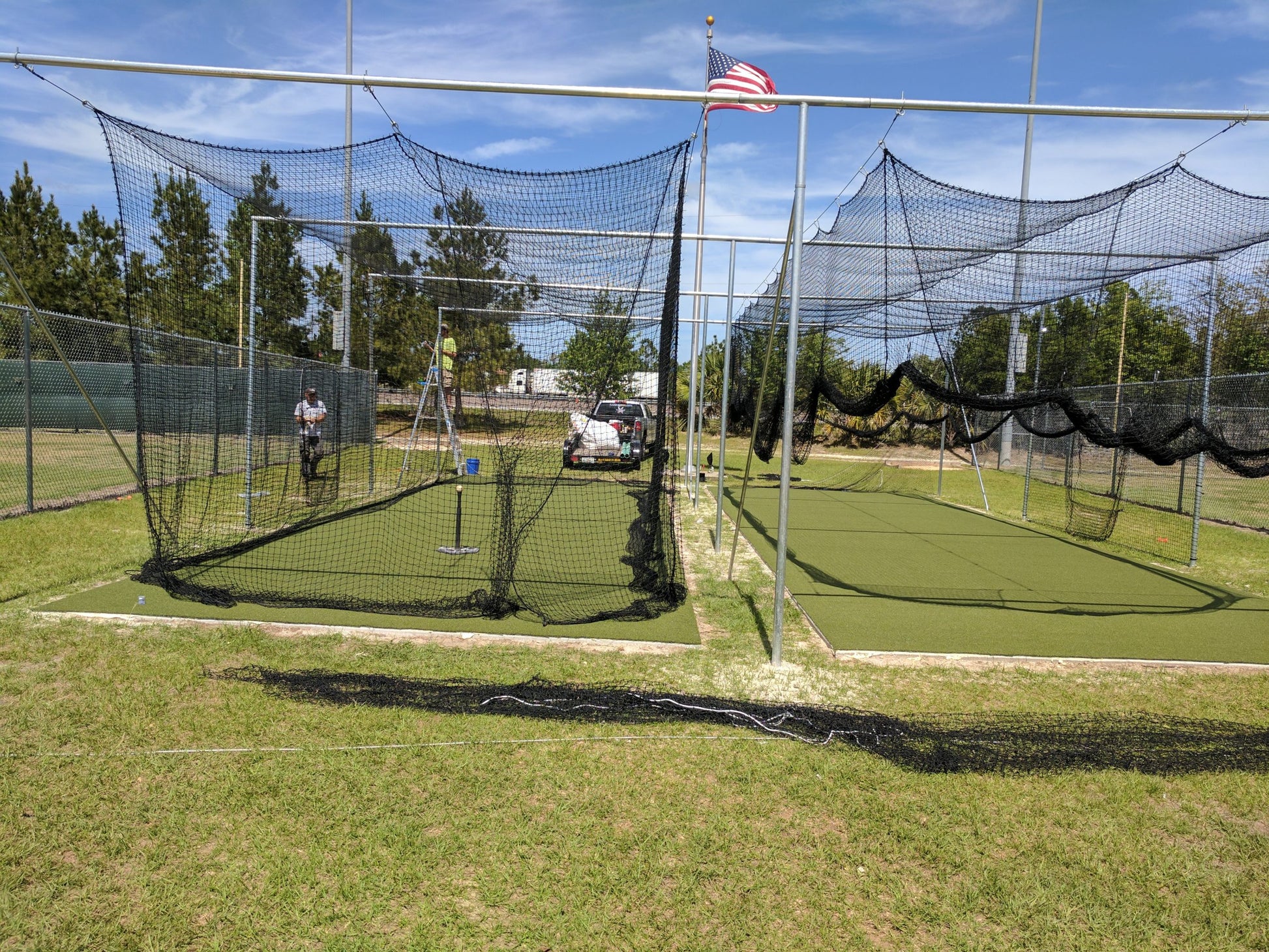 A baseball field with many batting cages in it