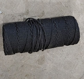 A roll of black rope on the ground.