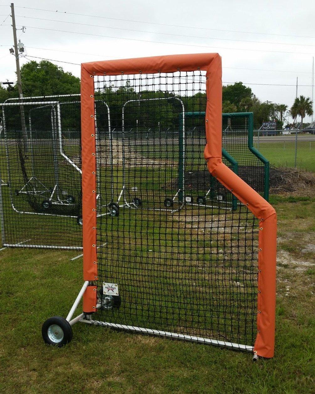 A baseball field with a batting cage and a ball cart.