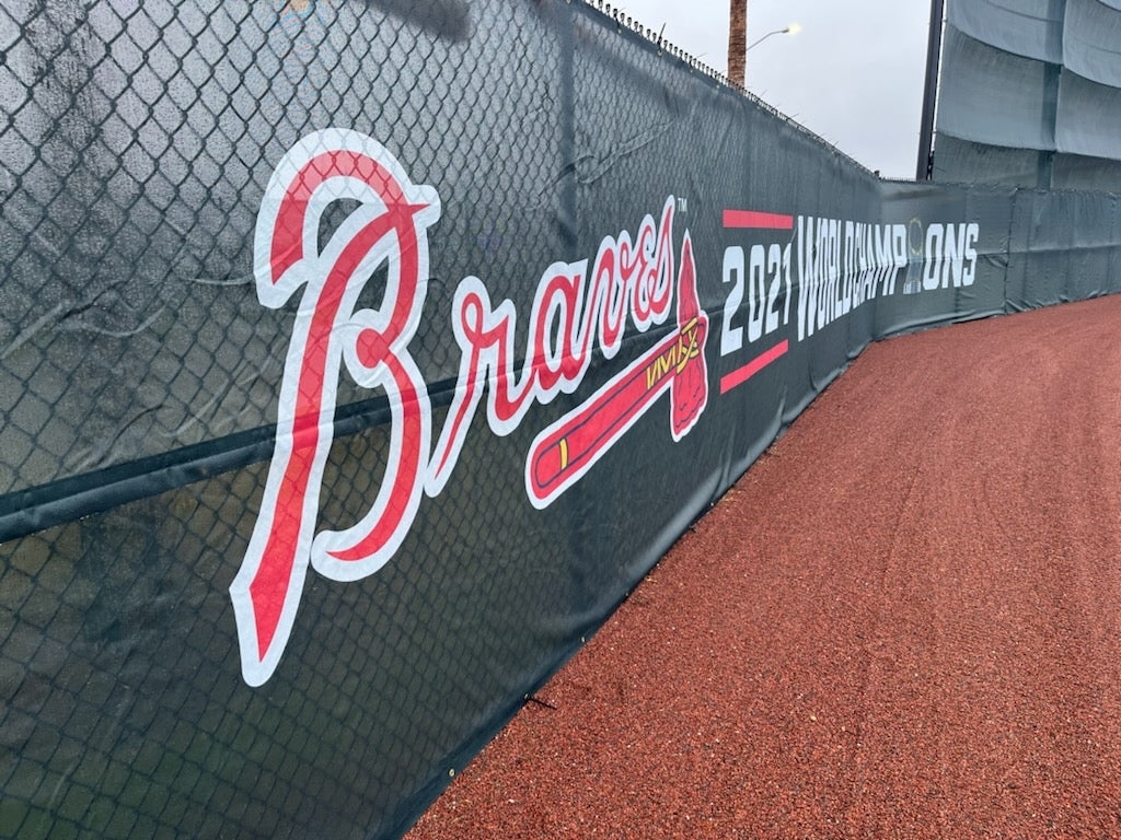 A baseball field with a fence and the atlanta braves logo.