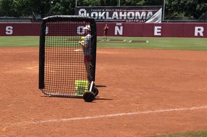 A person is holding a baseball bat on the field