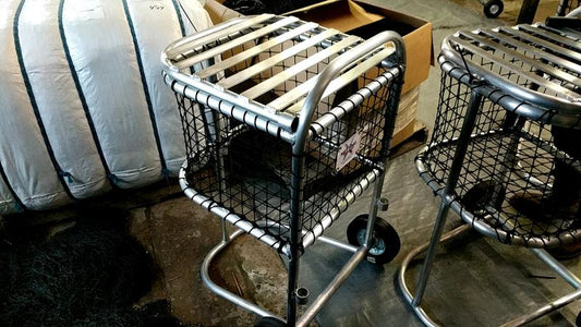 A cat sitting in a cage on top of a cart.