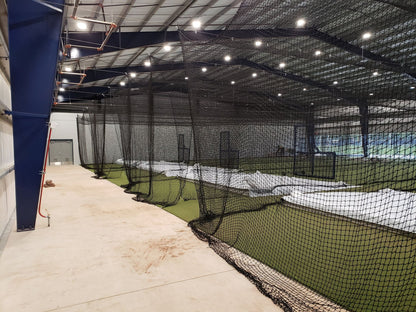A baseball field with many batting cages in it