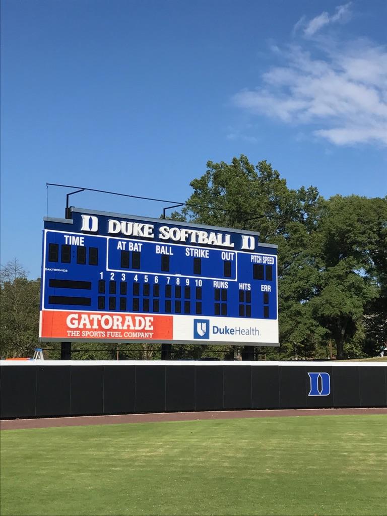 A large scoreboard on the side of a field.