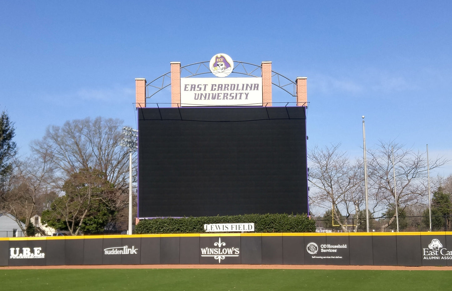 A large screen on top of a baseball field.