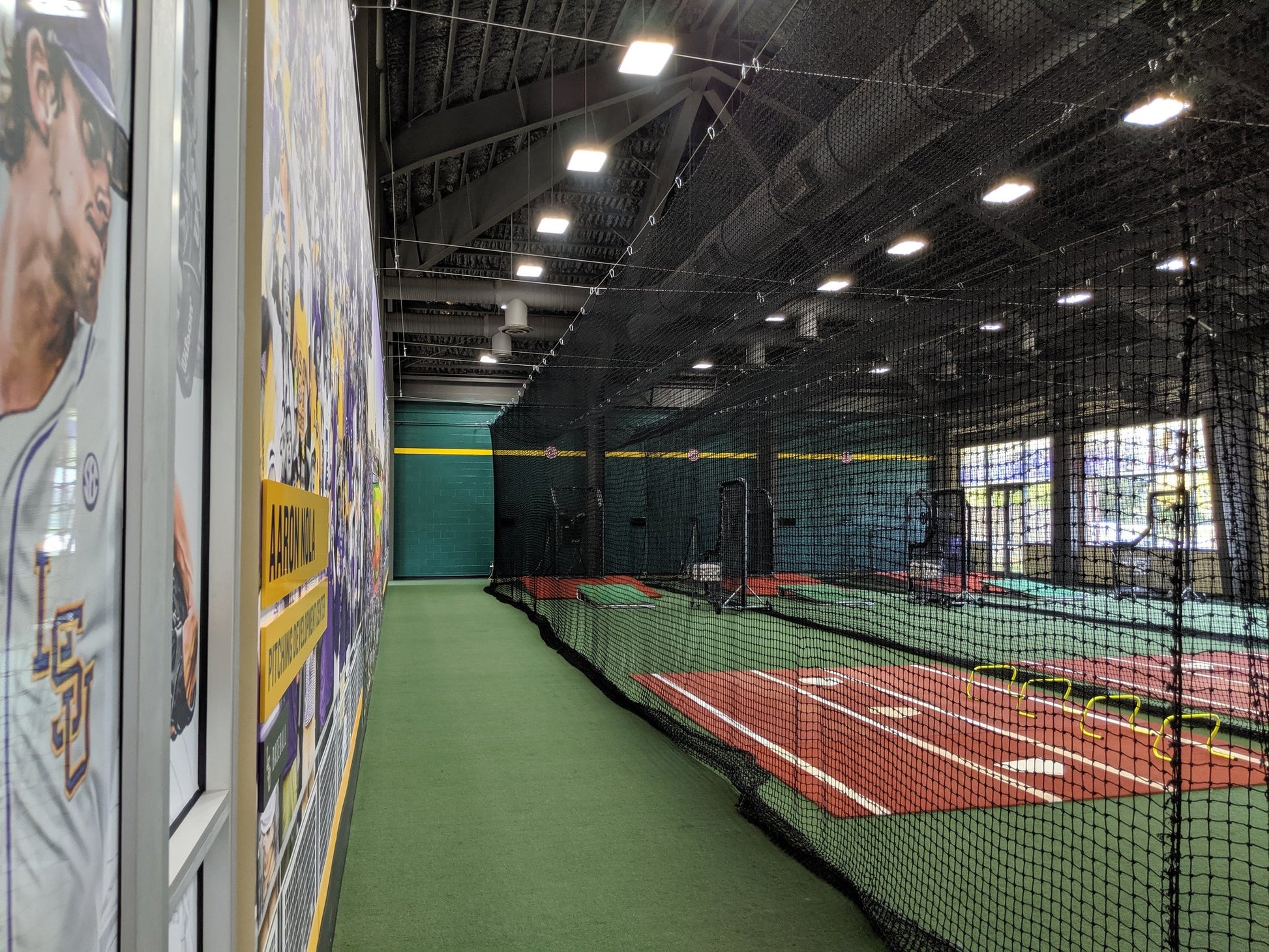 A tennis court with a net and lights on the wall.