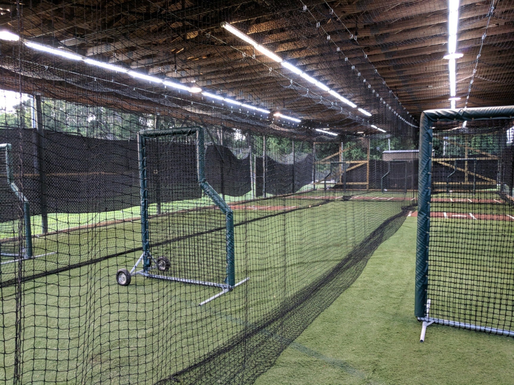 A baseball field with many batting cages in it