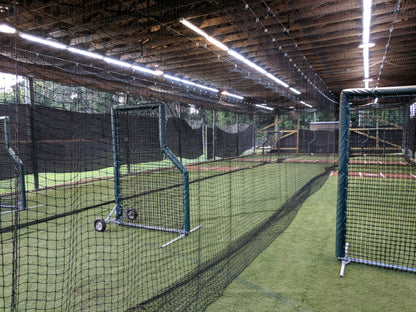 A baseball field with many batting cages in it