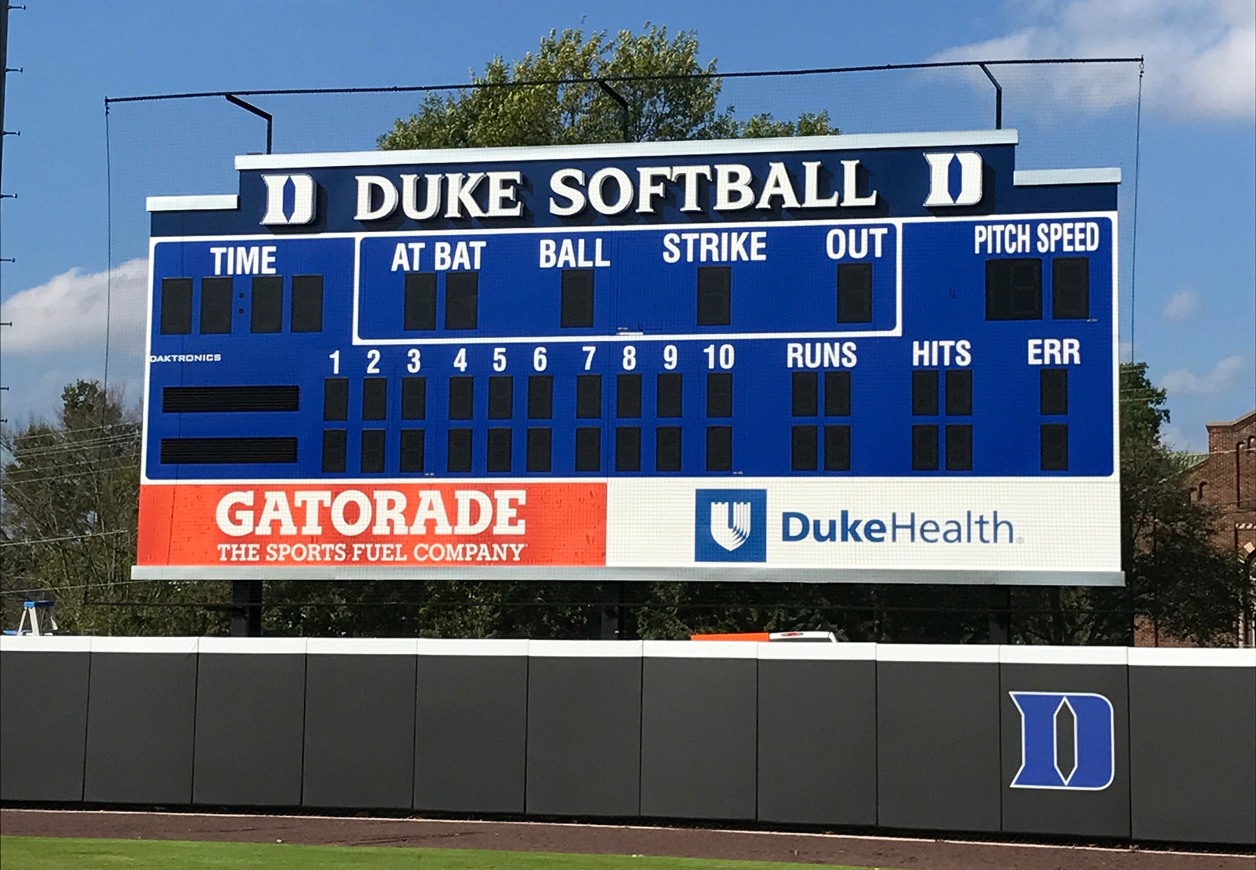 A large blue scoreboard with the duke softball team on it.