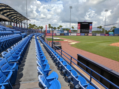 A baseball field with blue seats and bleachers.