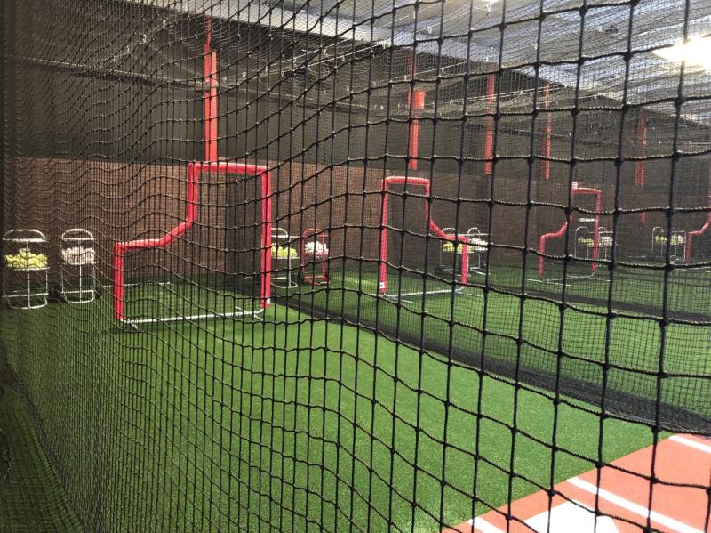 A baseball field with many balls in the middle of it