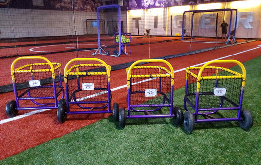A row of carts on the ground in front of a field.