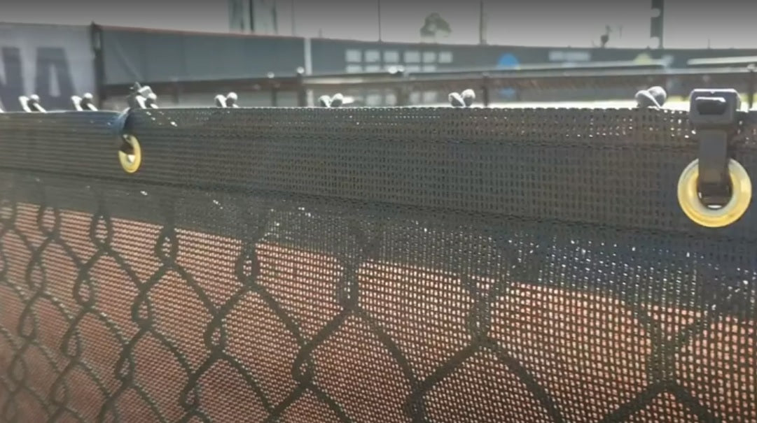 A fence with a view of the baseball field.