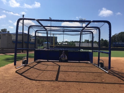 A baseball field with a cage on the ground.