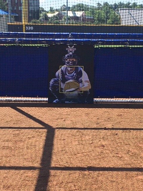 A baseball player is sitting on the ground