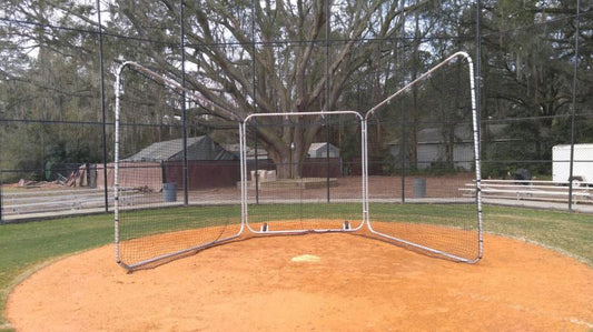 A baseball field with a base and net.